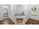 Bright entryway with hardwood floors, a console table, a decorative mirror, and a view into the powder room at 109 Camden Park Dr, Woodstock, GA 30188
