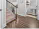 Hallway with hardwood floors, stairway, and powder room with a pedestal sink and decorative accessories at 109 Camden Park Dr, Woodstock, GA 30188