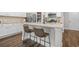 Elegant kitchen with granite countertops, white cabinets, stainless steel appliances, and a center island with bar seating at 109 Camden Park Dr, Woodstock, GA 30188