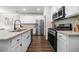 Modern kitchen features white cabinets, granite countertops, stainless steel appliances, and a large island with a black faucet at 109 Camden Park Dr, Woodstock, GA 30188