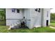 Exterior view of white home with steps to a side door and access to the crawl space on a grassy lawn at 119 E Johnson St, Temple, GA 30179