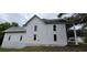 Side view of a two-story home showcasing white siding and a covered porch with round columns at 119 E Johnson St, Temple, GA 30179