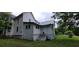 View of the side of the house with steps to a side door and access to the crawl space on a grassy lawn at 119 E Johnson St, Temple, GA 30179