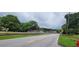 Wide street shot featuring railroad tracks and stop signs under a cloudy sky, with green foliage on either side at 119 E Johnson St, Temple, GA 30179