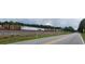 Road view near a train track with wood spools and a container trailer on a cloudy day at 119 E Johnson St, Temple, GA 30179
