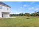 Expansive backyard with lush green grass, a charming young tree, and a partial view of the home at 3330 Carswell Bnd, Cumming, GA 30028