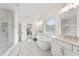 Luxury bathroom with marble floors, soaking tub, walk-in shower, double vanities, and abundant natural light at 3330 Carswell Bnd, Cumming, GA 30028