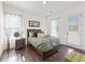 Bedroom with dark wood floors, a large bed, and natural light streaming in from two windows at 3330 Carswell Bnd, Cumming, GA 30028