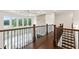 Foyer featuring hardwood floors, iron staircase, stone accent wall, and natural light from large windows at 3330 Carswell Bnd, Cumming, GA 30028