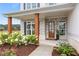 Home's front entrance featuring lush landscaping, stone work, and covered porch at 3330 Carswell Bnd, Cumming, GA 30028