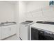 Functional laundry room featuring modern washer, dryer, sink, and storage shelf at 3330 Carswell Bnd, Cumming, GA 30028
