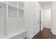 Bright mudroom area with white built-in storage, hooks, drawers, and access to closet and bath at 3330 Carswell Bnd, Cumming, GA 30028