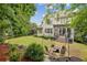 Beautiful backyard with a patio, stone firepit area, lush lawn, and mature trees at 3665 Pennington Rd, Cumming, GA 30041
