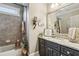Bathroom featuring granite counters, grey cabinetry, and tiled shower at 3665 Pennington Rd, Cumming, GA 30041