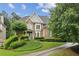 Charming two-story brick home with manicured lawn and lush landscaping, creating a welcoming curb appeal at 3665 Pennington Rd, Cumming, GA 30041