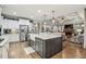 Gourmet kitchen featuring a central island, stainless steel appliances, and an open layout into living room at 3665 Pennington Rd, Cumming, GA 30041