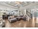 Spacious living room with coffered ceiling, open to kitchen and staircase at 3665 Pennington Rd, Cumming, GA 30041
