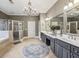 Luxurious main bathroom with double vanity, chandelier, shower, and soaking tub at 3665 Pennington Rd, Cumming, GA 30041