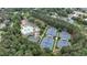 Aerial view highlighting tennis courts and a pool area nestled amongst dense trees and greenery at 119 Kennemer Ct, Johns Creek, GA 30097