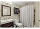 Functional bathroom featuring dark wood vanity, white tile, and a shower with a white curtain at 119 Kennemer Ct, Johns Creek, GA 30097