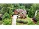 Aerial view of a red brick home with a large yard and mature trees providing a private, secluded feel at 119 Kennemer Ct, Johns Creek, GA 30097