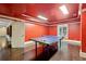 Game room with a ping pong table, hardwood floors, and a playful red color scheme at 119 Kennemer Ct, Johns Creek, GA 30097