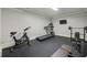 Home gym with rubber flooring, a treadmill, stationary bike, and weightlifting equipment for a complete workout at 119 Kennemer Ct, Johns Creek, GA 30097