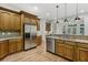 Well-equipped kitchen featuring stainless steel appliances, granite countertops, and wooden cabinets at 119 Kennemer Ct, Johns Creek, GA 30097