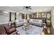 Spacious living room featuring hardwood floors, comfortable seating, a wet bar, and neutral decor at 119 Kennemer Ct, Johns Creek, GA 30097