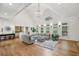 Expansive living room featuring vaulted ceilings, a modern sectional, and hardwood floors with a view of the kitchen at 119 Kennemer Ct, Johns Creek, GA 30097