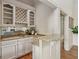 Wet bar area featuring stone countertops, white cabinetry, mirrored backsplash and hardwood floors at 119 Kennemer Ct, Johns Creek, GA 30097