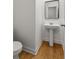 A minimalist powder room with hardwood floors, a pedestal sink, and a framed mirror at 90 Grove Park Ln, Woodstock, GA 30189