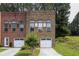 Brick townhome exterior with garage, front yard, and beautiful, timeless architectural details at 90 Grove Park Ln, Woodstock, GA 30189