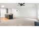 A spacious living room featuring a modern ceiling fan and an adjacent kitchen area with modern appliances at 90 Grove Park Ln, Woodstock, GA 30189