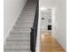 Carpeted staircase featuring a dark wood banister contrasted with light walls and hardwood floors at 90 Grove Park Ln, Woodstock, GA 30189