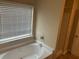 Bathroom featuring a jetted tub under a large window at 3140 Tylerton Sw Dr, Atlanta, GA 30311