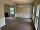 Bright living room featuring carpet, windows, decorative molding and an elegant chandelier at 3140 Tylerton Sw Dr, Atlanta, GA 30311