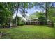 Spacious backyard featuring a large lawn, wooden deck, and mature trees offering a serene outdoor setting at 2640 Spring Se Dr, Smyrna, GA 30080