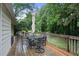 View of the outdoor deck with outdoor dining table and chairs surrounded by lush greenery and trees at 2640 Spring Se Dr, Smyrna, GA 30080