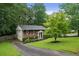 Well-maintained brick home featuring a driveway, manicured lawn, and lush green trees at 2640 Spring Se Dr, Smyrna, GA 30080