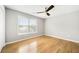 Bedroom features wood floors, a ceiling fan, and natural light from a large window at 4188 Cookcreek Place Northwest Nw Pl, Lilburn, GA 30047