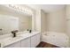 Bathroom featuring double sinks, jacuzzi tub, and a large mirror at 4593 Parkway Cir, Atlanta, GA 30349