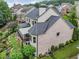 A verdant backyard featuring a covered patio and a stone walkway lined with manicured landscaping at 7060 Summit Ridge Chase, Cumming, GA 30041