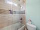 Updated bathroom with a shower-tub combo, sleek tile, and built-in shelving at 7060 Summit Ridge Chase, Cumming, GA 30041