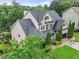 An upscale two-story home with a landscaped lawn, featuring an attached garage and manicured privacy shrubs at 7060 Summit Ridge Chase, Cumming, GA 30041