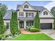 Charming two-story brick home featuring a well-manicured lawn and attached two-car garage at 7060 Summit Ridge Chase, Cumming, GA 30041