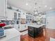 Well-lit kitchen with white cabinetry, mosaic backsplash, stainless appliances, and black island at 7060 Summit Ridge Chase, Cumming, GA 30041