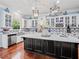 Bright kitchen featuring an island with a white countertop, black cabinets, stainless steel appliances, and pendant lights at 7060 Summit Ridge Chase, Cumming, GA 30041
