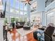 Two-story living room with large windows, hardwood floors, comfortable seating, and a fireplace at 7060 Summit Ridge Chase, Cumming, GA 30041