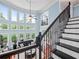 Two-story living room with hardwood floors, a staircase, a ceiling fan, and comfortable seating at 7060 Summit Ridge Chase, Cumming, GA 30041